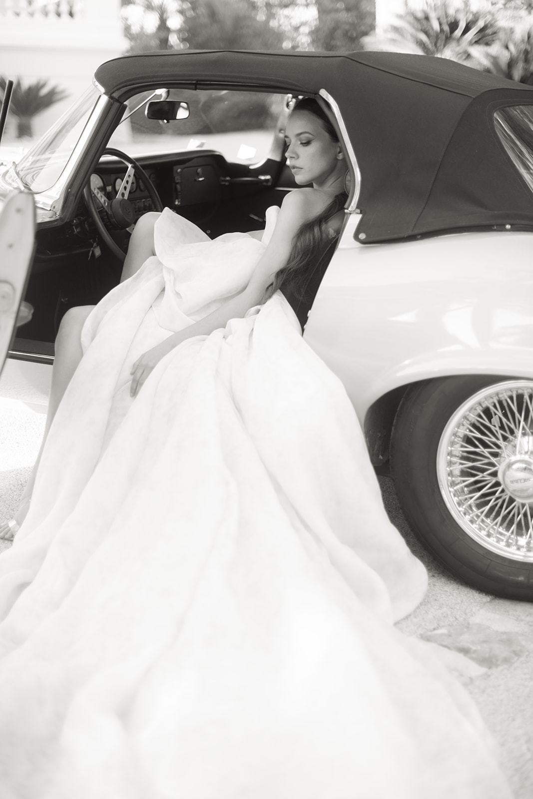 Bride in a couture gown beside a classic Jaguar near Saint-Tropez